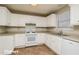 White kitchen with ample counter space and tile floor at 415 Gresham Dr, Stockbridge, GA 30281