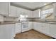 Kitchen with white cabinets, tile floor, and gas range at 415 Gresham Dr, Stockbridge, GA 30281