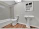 Basement bathroom with a pedestal sink, toilet, and bathtub at 4179 White Rd, Snellville, GA 30039