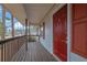 Red front door entryway with wooden deck and railing at 4179 White Rd, Snellville, GA 30039