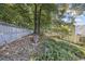 Sloped backyard with a wooden fence and lots of trees at 1855 Charleston Oak Cir, Lawrenceville, GA 30043