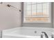 Soaking tub with large window and neutral wall colors at 1855 Charleston Oak Cir, Lawrenceville, GA 30043