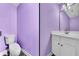 Powder room with white vanity and purple walls at 1855 Charleston Oak Cir, Lawrenceville, GA 30043