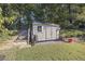 Tan colored storage shed with a window and double doors at 1855 Charleston Oak Cir, Lawrenceville, GA 30043