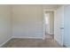 Bright bedroom with neutral carpet, white trim, and a door to the hallway at 1890 Old Concord Se Dr, Covington, GA 30016