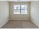 Empty bedroom with large window and plush carpet flooring at 1890 Old Concord Se Dr, Covington, GA 30016