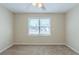 Bedroom with a large window overlooking the backyard, neutral carpet and ceiling fan at 1890 Old Concord Se Dr, Covington, GA 30016