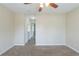 Bedroom with neutral carpet, ceiling fan, hallway access, and a large window at 1890 Old Concord Se Dr, Covington, GA 30016