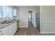 Well-lit kitchen featuring white cabinets, stainless steel appliances, and wood-look flooring at 1890 Old Concord Se Dr, Covington, GA 30016