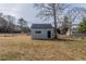 Gray shed in a grassy backyard with a chain link fence and mature trees at 1890 Old Concord Se Dr, Covington, GA 30016