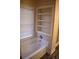 Bathroom with built-in shelving, window, and bathtub at 95 Twin Lakes Dr, Carrollton, GA 30116