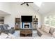 Cozy living room with a fireplace, bookshelves, a ceiling fan, and hardwood floors at 1164 Pine Grove Dr, Alpharetta, GA 30009