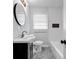 This bathroom features a vanity with a round mirror and a tiled shower and bathtub at 6467 Joanna St, Lithia Springs, GA 30122