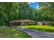 Ranch home with covered parking featuring a long driveway and mature trees at 6467 Joanna St, Lithia Springs, GA 30122