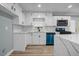 Bright kitchen features white cabinets, quartz counters, and a modern, stainless steel appliance at 6467 Joanna St, Lithia Springs, GA 30122
