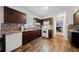 Spacious kitchen with dark wood cabinets, mosaic backsplash, and hardwood floors at 1956 Spencer Oaks Ln, Lithonia, GA 30058