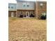 Backyard with brown grass and view of the brick exterior elevation at 11118 Benton Woods Dr, Covington, GA 30014