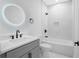 Clean bathroom featuring a gray vanity, white marble tile, and a frameless mirror at 2195 Springdale Sw Rd, Atlanta, GA 30315