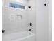 Modern bathroom with white tile, bathtub, and black fixtures at 2195 Springdale Sw Rd, Atlanta, GA 30315