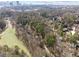 Aerial view showcasing a house nestled in a wooded neighborhood with city skyline in the distance at 1992 Walthall Nw Dr, Atlanta, GA 30318