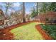 Landscaped backyard with a grassy area, pine straw, and white fence at 1992 Walthall Nw Dr, Atlanta, GA 30318