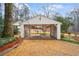 White carport with brick base and gravel driveway at 1992 Walthall Nw Dr, Atlanta, GA 30318