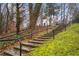 Stone steps leading to a charming house with black railings, surrounded by lush greenery at 1992 Walthall Nw Dr, Atlanta, GA 30318