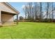 A backyard featuring a view of the lawn and a home with light siding and a dark roof at 3921 Brushy St, Powder Springs, GA 30127