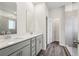 Modern bathroom featuring a double sink vanity, a glass-enclosed shower, and stylish wood-look flooring at 3921 Brushy St, Powder Springs, GA 30127