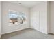 Well-lit bedroom with plush carpet, two windows, and white door at 3921 Brushy St, Powder Springs, GA 30127