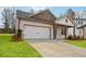 A view of the attractive one-story house with an attached garage, a well-kept lawn, and a concrete driveway at 3921 Brushy St, Powder Springs, GA 30127