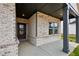 A welcoming covered front porch features stone columns and a brick facade leading to a glass-paneled front door at 3921 Brushy St, Powder Springs, GA 30127