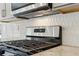 Close-up of the kitchen range with stainless steel appliances and stylish backsplash at 3921 Brushy St, Powder Springs, GA 30127