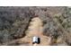 Aerial view of a shed in a large grassy yard surrounded by dense trees and a small stream, capturing the property's expanse at 4760 Green Summers Dr, Cumming, GA 30028