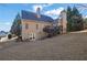 Back exterior view of a tan house with a deck, a patio, and a sloped backyard at 4760 Green Summers Dr, Cumming, GA 30028