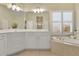 Bright bathroom featuring double vanity, large window with shutters, and soaking tub at 4760 Green Summers Dr, Cumming, GA 30028