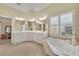 Bright bathroom featuring double vanity, large window with shutters, and soaking tub at 4760 Green Summers Dr, Cumming, GA 30028