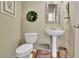 Charming powder room with pedestal sink and decorative mirror at 4760 Green Summers Dr, Cumming, GA 30028