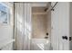 Bright bathroom featuring tiled shower and tub with white shower curtain, and natural light at 919 Ormewood Se Ave, Atlanta, GA 30316