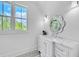 Bright bathroom boasts a white vanity with marble countertop, decorative mirror, and patterned floor tile at 103 Arbor Oaks Dr, Canton, GA 30115