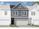 Two-story townhome with gray siding, white trim, and a two-car garage at 1149 Chastain Dr # 62, Sugar Hill, GA 30518