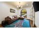 Cozy sitting room with plush leather sofa, unique rug, and natural light from the arched window at 89 Somerset Ln, Cartersville, GA 30121