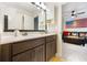 Bathroom featuring double sink vanity with dark cabinets and a glimpse into the living room at 1121 Red Oak Ln, Loganville, GA 30052