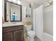 Bathroom with dark wood vanity and a shower and tub with a white curtain at 1121 Red Oak Ln, Loganville, GA 30052