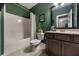 Bathroom with a tub shower combo, dark vanity, and green walls at 1121 Red Oak Ln, Loganville, GA 30052