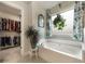 Bathroom showcasing a garden tub with blue and floral curtains and walk-in closet at 1121 Red Oak Ln, Loganville, GA 30052