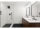 Modern bathroom features double sinks, a walk-in shower, and black-and-white tiling for a modern aesthetic appeal at 1956 Gober Se Ave, Smyrna, GA 30080