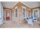 Cozy covered porch with brick flooring, rocking chairs, and a view of the front yard, perfect for relaxing outdoors at 115 Hedgewood Ln, Canton, GA 30115