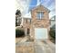 Brick townhouse with a white garage door and landscaping at 1635 River Main Ct, Lawrenceville, GA 30044