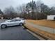 Parking lot with cars parked and a sidewalk leading to a wooded area at 1635 River Main Ct, Lawrenceville, GA 30044